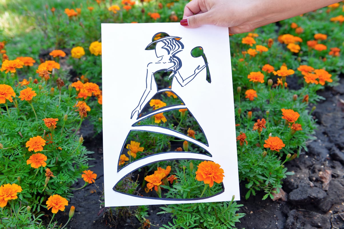 Person Holding a Fashion Sketch with a Cutout Outdoors